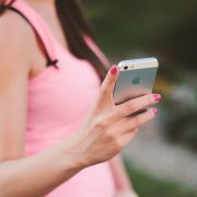 Mulher usa um smartphone ao ar livre em um dia ensolarado.