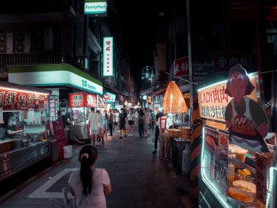 Feira Noturna de Jundiapeba começa a funcionar aos sábados em Mogi das Cruzes 19 Feira noturna ao ar livre, com barracas de comida iluminadas e pessoas circulando entre os estandes.