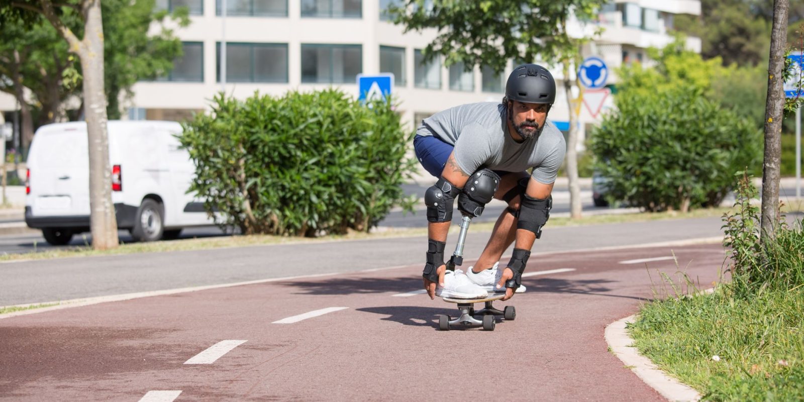 Pessoa com prótese na perna andando de skate ao ar livre em um dia ensolarado