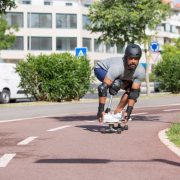 Pessoa com prótese na perna andando de skate ao ar livre em um dia ensolarado