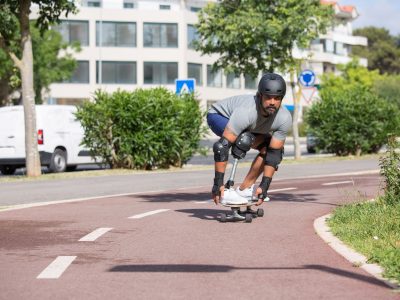 Pessoa com prótese na perna andando de skate ao ar livre em um dia ensolarado