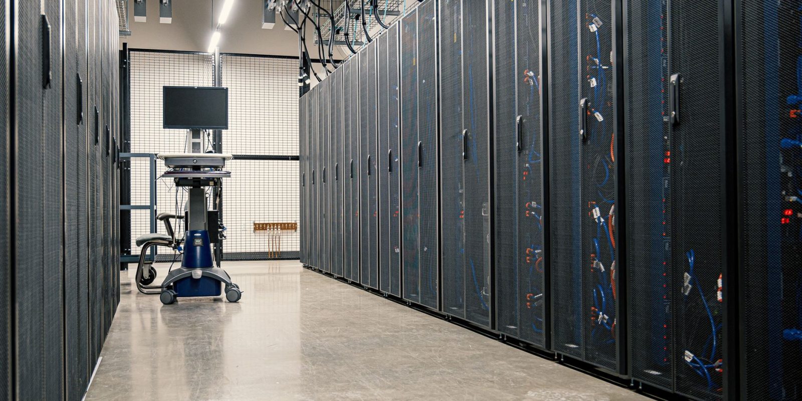 Lei cria regime tributário para data centers e exige investimentos em tecnologia no Brasil 17 Armários metálicos com servidores, dispositivos de rede e cabos no interior de um data center moderno.
