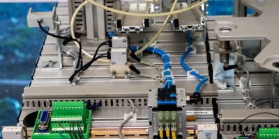 Close de equipamentos industriais com fiação e sensores eletrônicos em uma configuração tecnológica.
