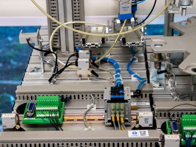 Close de equipamentos industriais com fiação e sensores eletrônicos em uma configuração tecnológica.