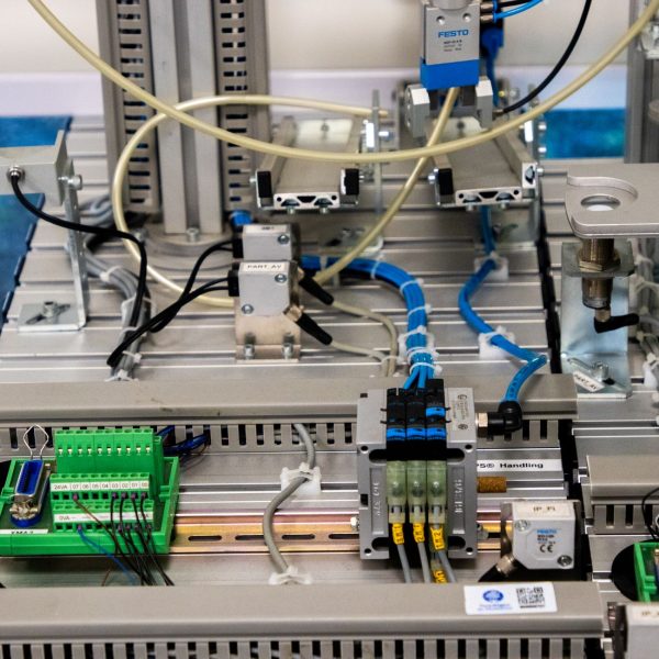 Close de equipamentos industriais com fiação e sensores eletrônicos em uma configuração tecnológica.