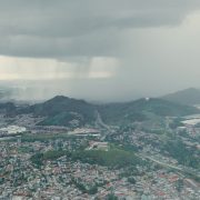 Tempestade se aproxima de uma extensa área urbana vista de cima.