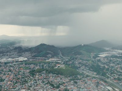 Tempestade se aproxima de uma extensa área urbana vista de cima.
