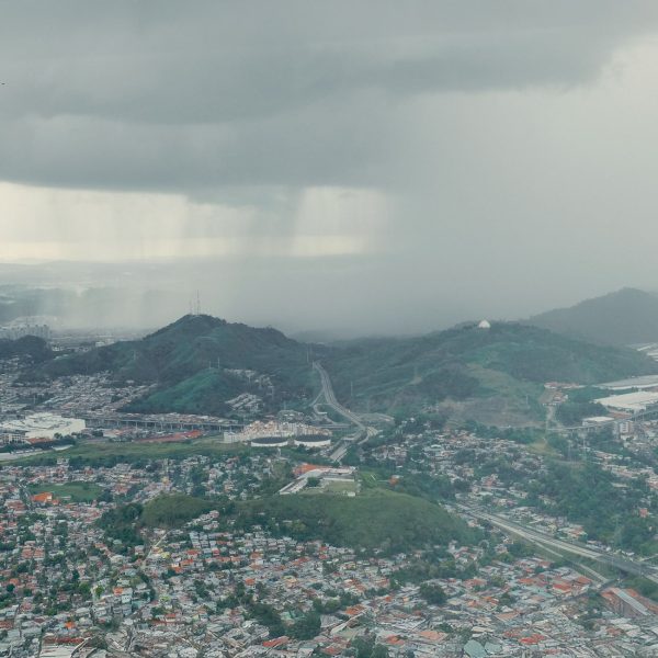 Tempestade se aproxima de uma extensa área urbana vista de cima.