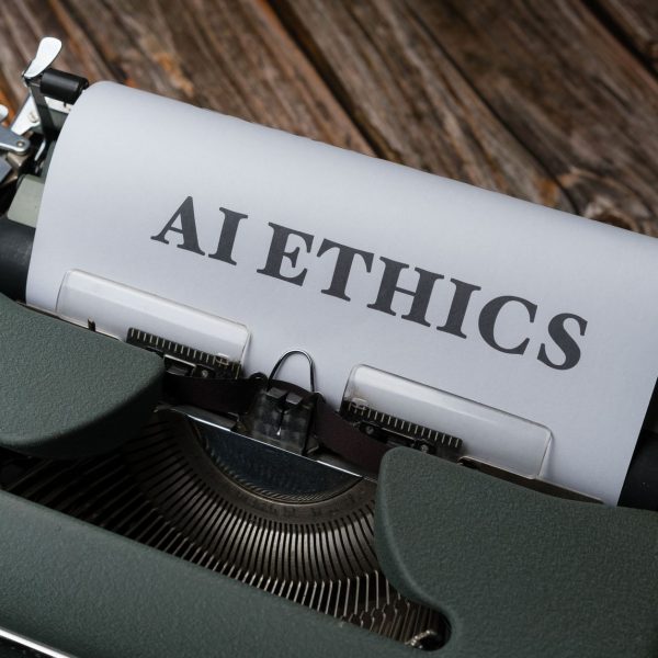 Máquina de escrever antiga com as palavras “AI Ethics” digitadas em uma folha de papel.